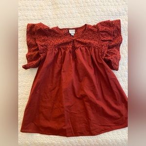 Rust-red eyelet top.